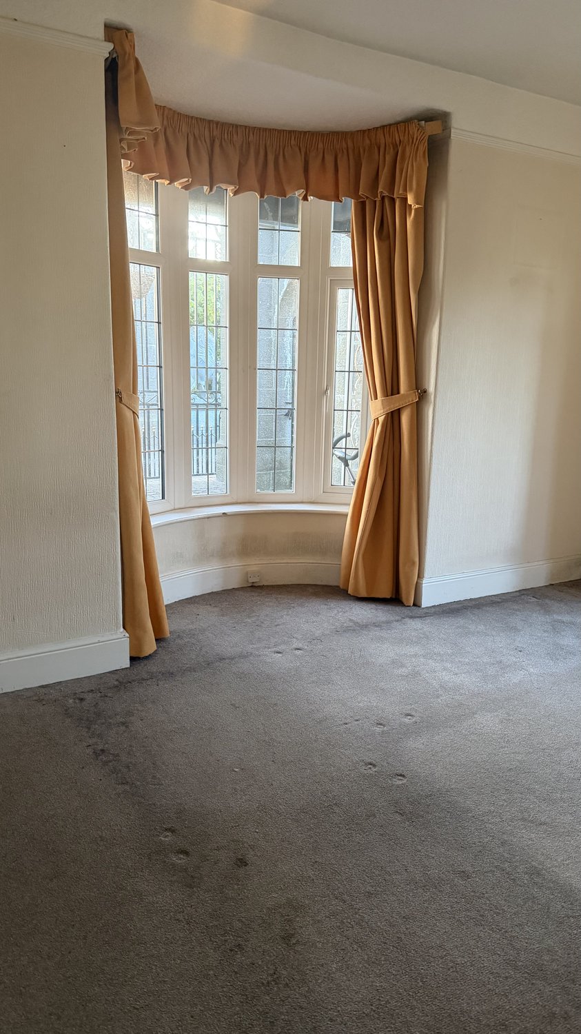 Living room with worn carpet before professional carpet cleaning