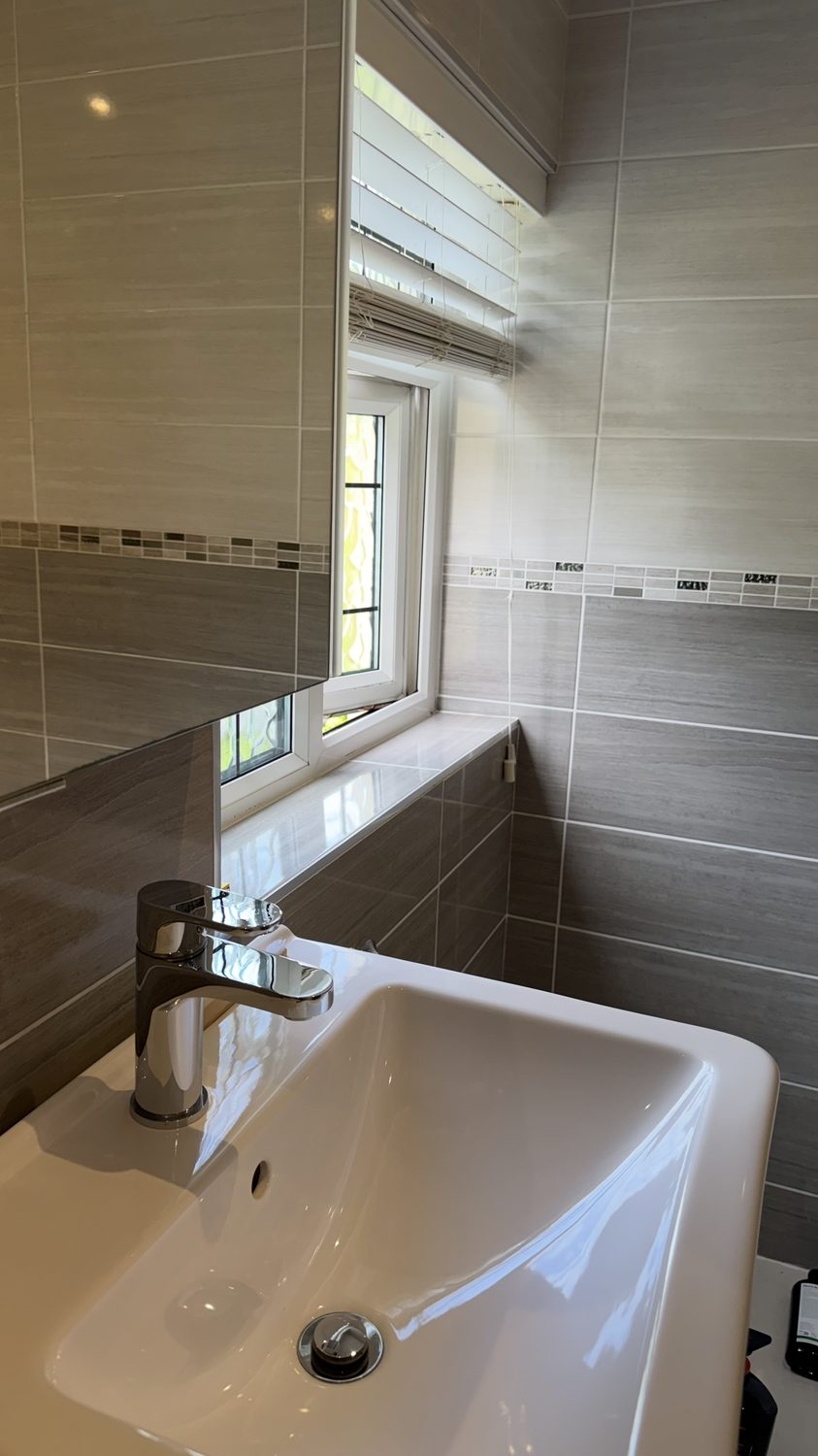 Spotless bathroom vanity sink and tiling after professional cleaning